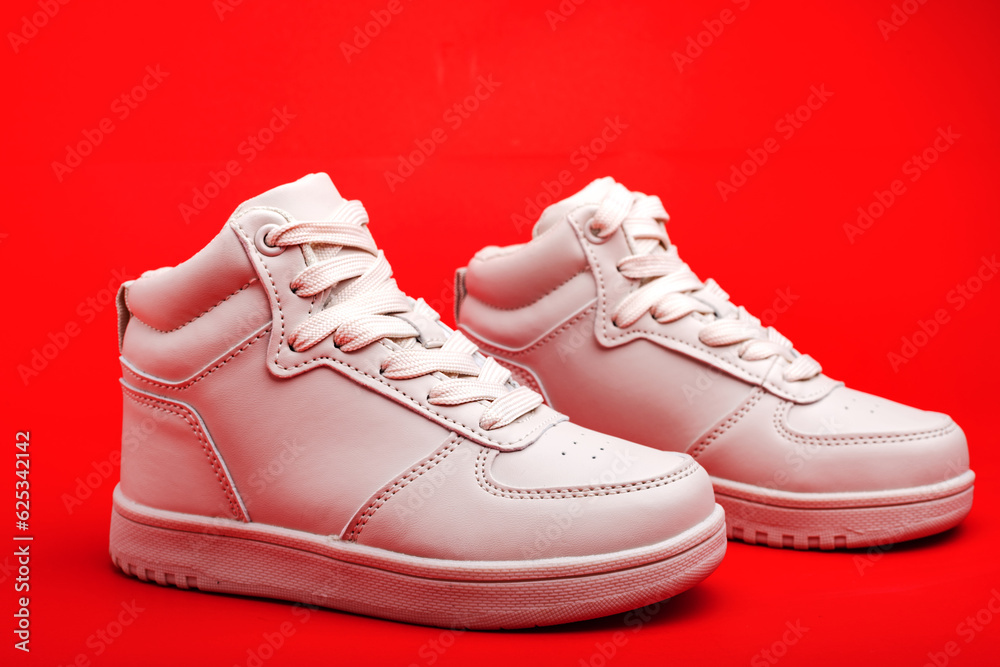 youth high sneakers on red background close-up.
