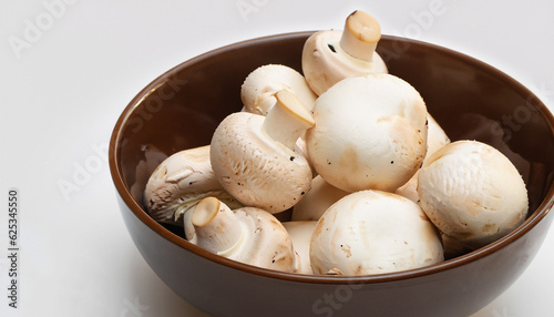 Fresh white mushrooms champignon in brown bowl on white background.