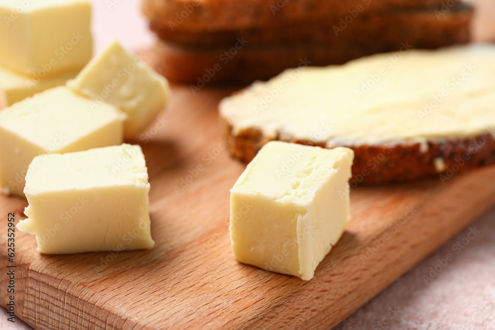 Pieces of fresh butter on wooden board, closeup