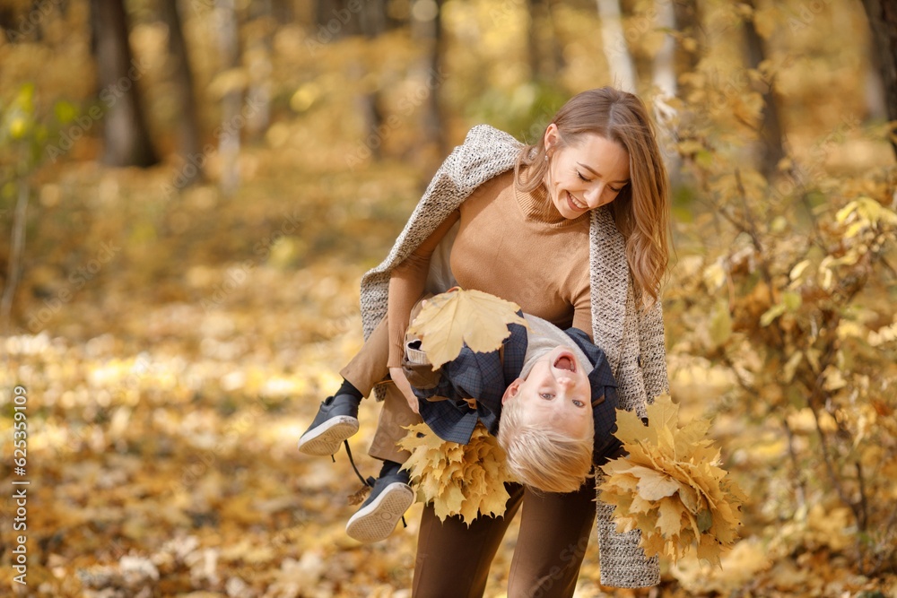 Mother and her son playing and having fun in autumn forest Mother and her son playing and having fun in autumn forest