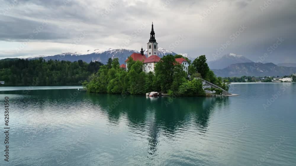 Aerial around view of Bled lake with the Pilgrimage Church of the Assumption of Maria on a small island after sunset, Slovenia, 4k