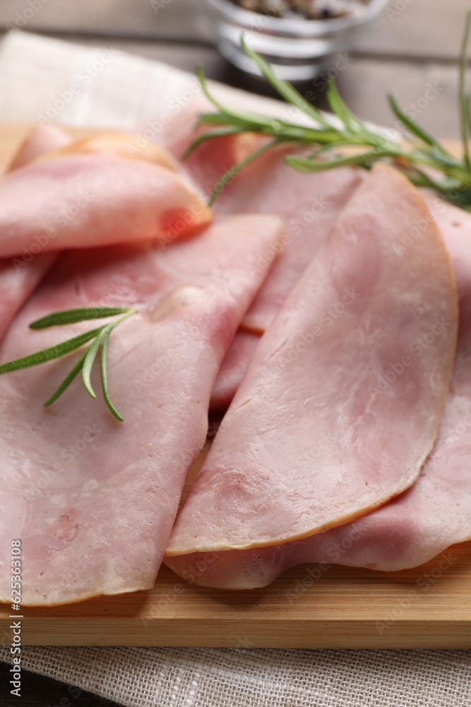 Slices of delicious ham with rosemary on table, closeup Slices of delicious ham with rosemary on table, closeup