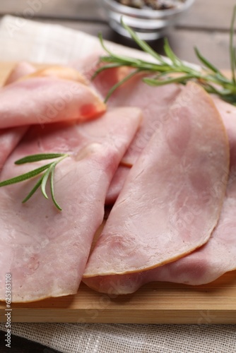 Slices of delicious ham with rosemary on table, closeup