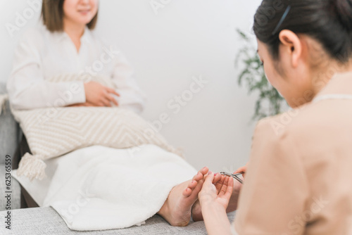 Fotografie, Obraz ネイルサロンで巻き爪・爪の治療・ペディキュア・フットネイルをする女性