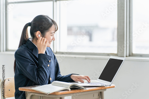 学校・塾でパソコンとイヤホンを使って英語を勉強する高校生（ICT教育・オンライン学習）
 photo