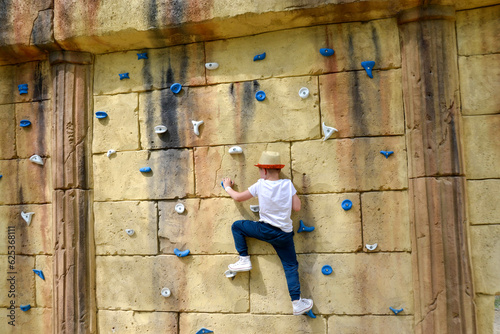 The boy is engaged in rock climbing. photo