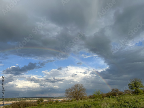 storm clouds and rainbow over the river