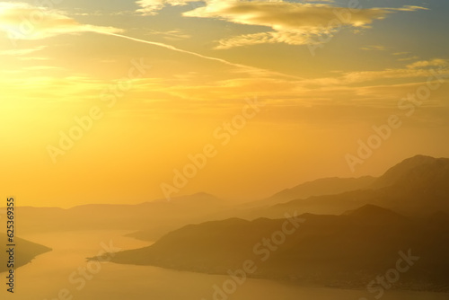 Aerial top view of mountains range and Boka Kotorska bay of Adriatic sea, Montenegro. Picturesque sunset landscape.