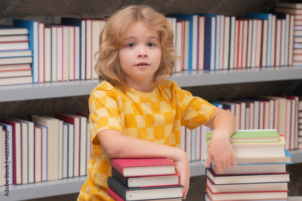 Knowledge day. Back to school. School kid pupil studying in school library. Child reading book in library on bookshelf background. Knowledge day. Back to school. School kid pupil studying in school library. Child reading book in library on bookshelf background.