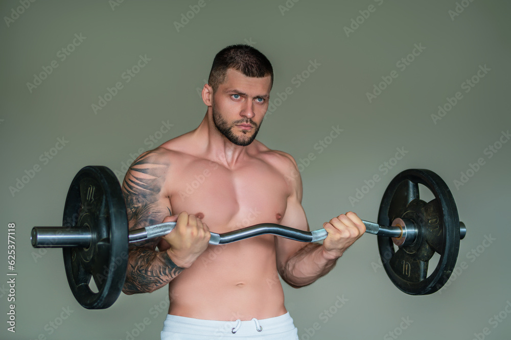 Sexy muscular man pumps his muscles and lifts barbell in gym. Strong fit man exercising with barbell. Muscular young handsome man lifting weights. Weightlifting and training with barbell. Sexy muscular man pumps his muscles and lifts barbell in gym. Strong fit man exercising with barbell. Muscular young handsome man lifting weights. Weightlifting and training with barbell.
