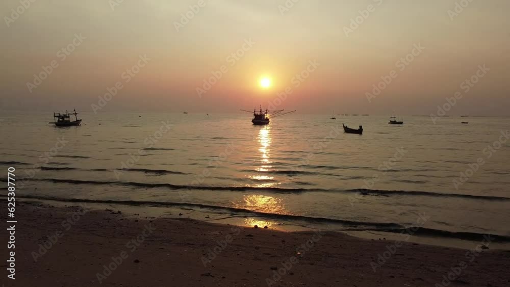 Static shot from beach showing stunning sunset in Thailand with local fishing boat silhouettes. Static shot from beach showing stunning sunset in Thailand with local fishing boat silhouettes.