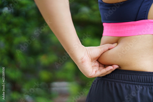 Fotografia Unhealthy overweight Asian fat woman catching on her big belly and arm close up