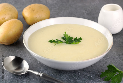 Murais de parede Bowl of creamy potato soup with ingredients on a gray background