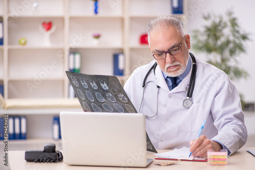 Old male doctor radiologist working in the clinic