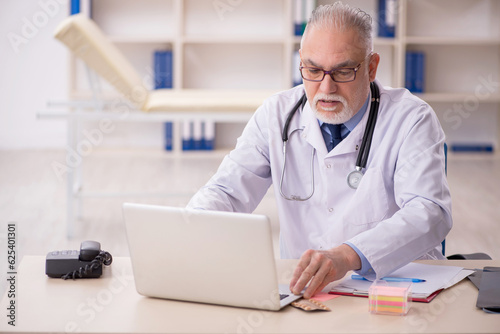 Old male doctor working in the clinic