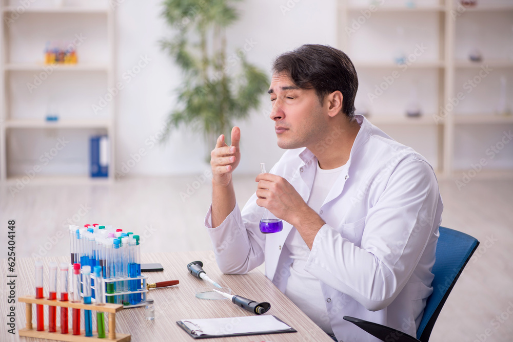 Young male chemist working at the lab Young male chemist working at the lab