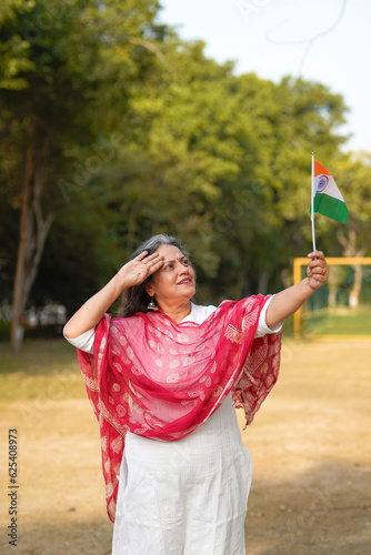 Indian woman waving and salute of national tricolor flag.