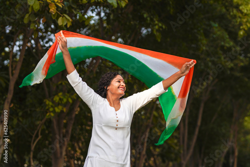 Indian woman waving tricolor cloth or odhani at park. photo