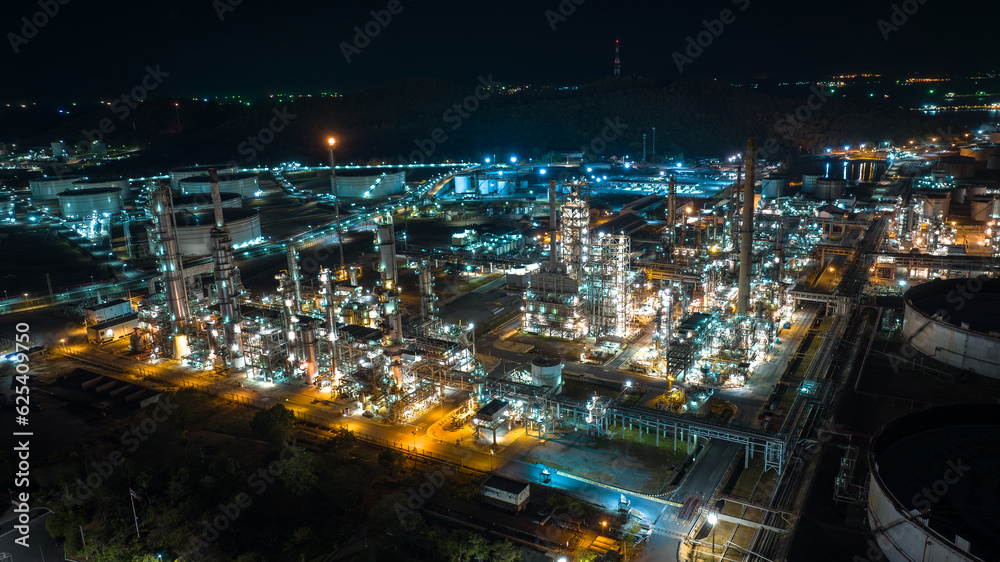 Oil refinery plant industry factory zone, oil and gas petrochemical industrial, oil storage tank and pipeline steel at night scene shot, aerial view