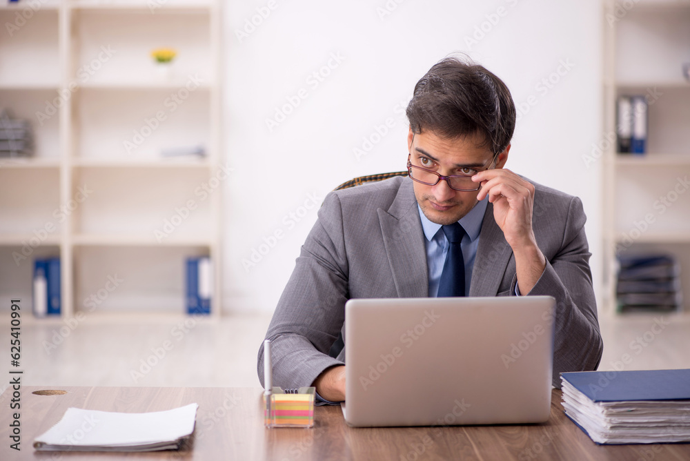Young male employee working in the office Young male employee working in the office