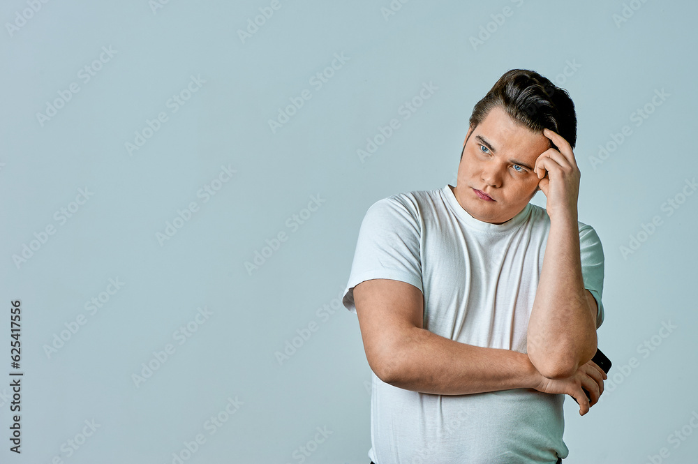 A man looks at the phone screen on a gray background A man looks at the phone screen on a gray background