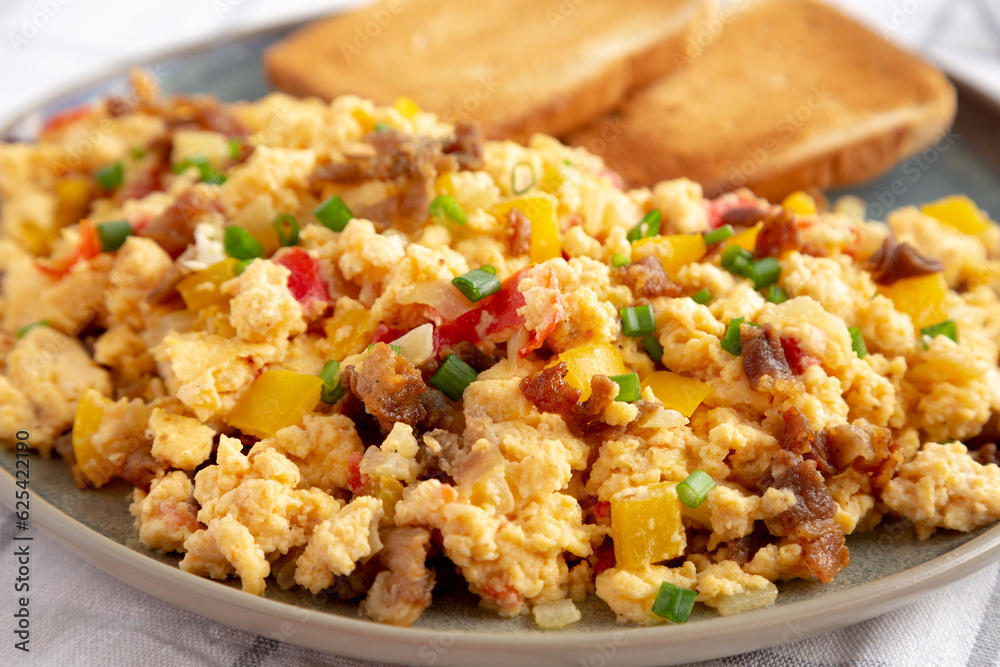 Homemade Fiesta Scrambled Eggs with Peppers and Toast on a Plate, side view. Close-up. Homemade Fiesta Scrambled Eggs with Peppers and Toast on a Plate, side view. Close-up.