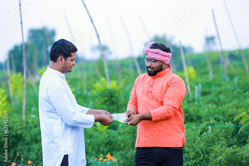 Indian farmer giving money to his worker