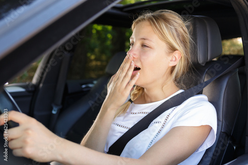 a sleepy yawning woman driving © auremar