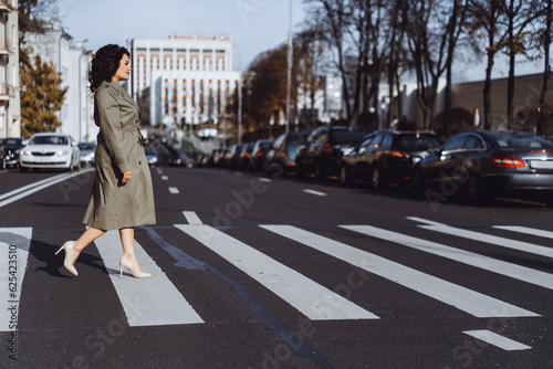 Young woman walks on the crossroad through the autumn city © Cavan