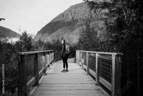 Young Woman Hiking On Bridge In Alaska