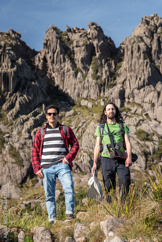 Naklejka premium Beautiful view to couple of friends hiking on altitude fields