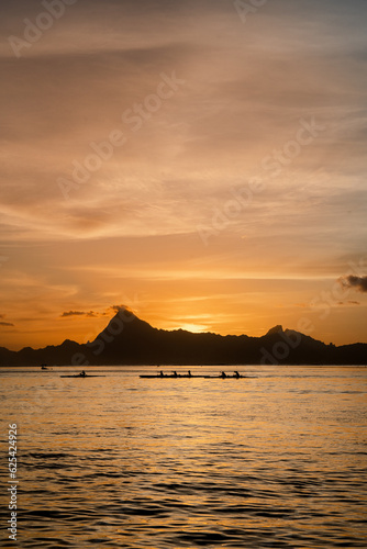 Sunset view Moorea island French Polynesia group of canoes