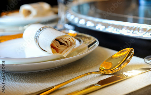 Fork and knife on a napkin with plate, elegant dinner photo