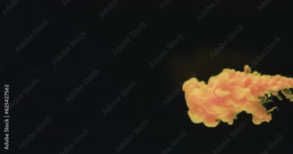 Slow motion video of yellow watercolor ink mixing in water against black background Slow motion video of yellow watercolor ink mixing in water against black background
