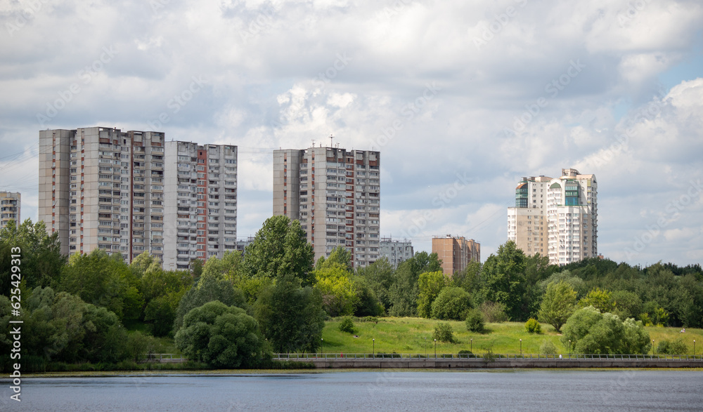 Multi-storey buildings in the green zone of the park against the sky. Multi-storey buildings in the green zone of the park against the sky.