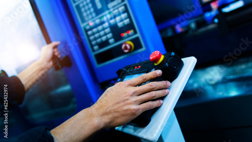 Worker hand controling cnc machine at workshop photo