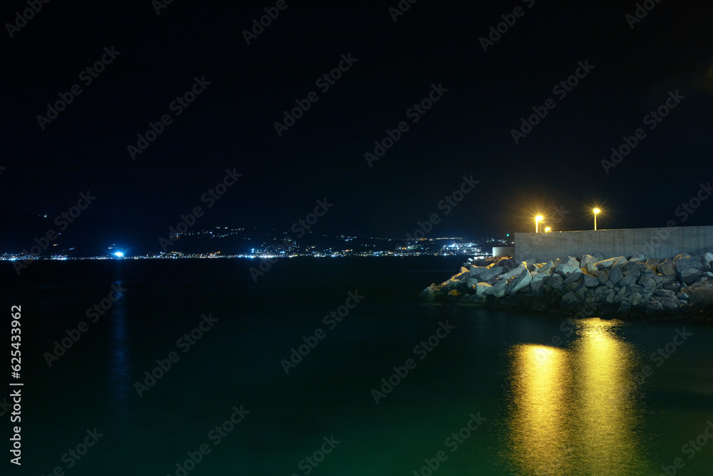 Photograph of the Villa San Giovanni coastline at night and the island of Sicily