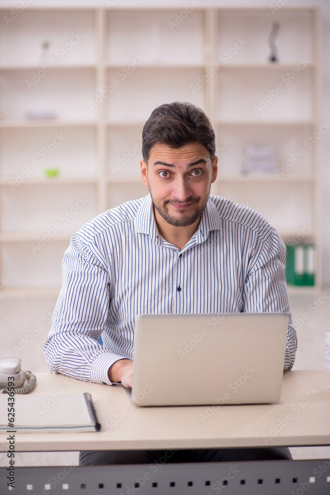 Young male employee working in the office Young male employee working in the office