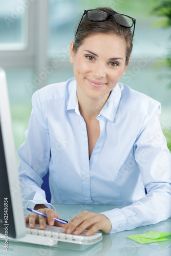 Fotografia portrait of beautiful clerical worker at computer desk
