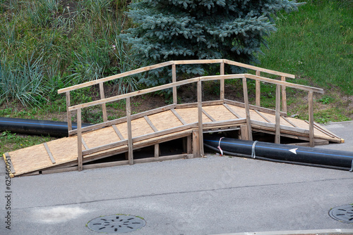 Fényképezés temporary wooden bridge over the pipe on construction site
