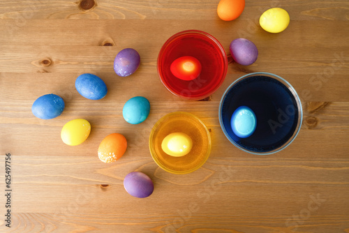 Colorful easter eggs on a wooden table. Top view.