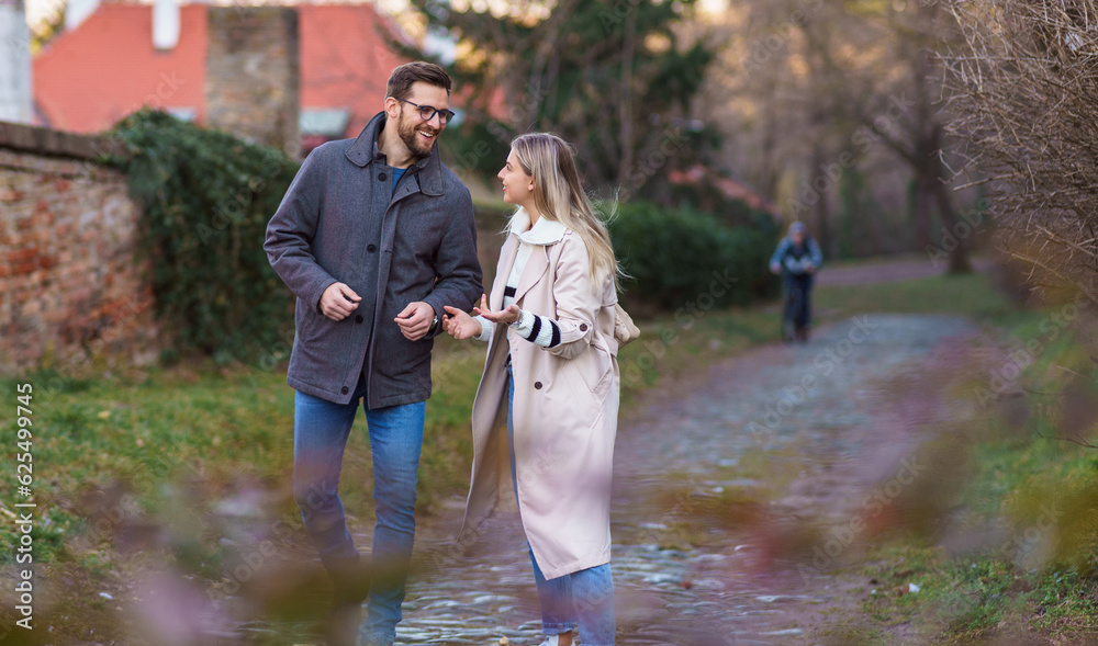 Obraz premium A portrait of a happy romantic couple walking outdoors in the surroundings of an old fortress