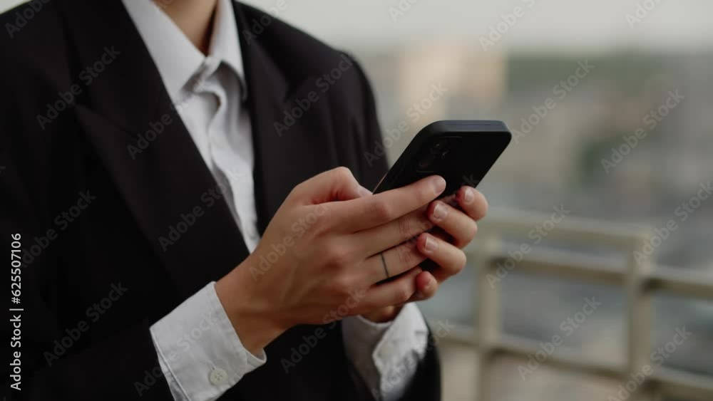 Close-up of attractive young businesswoman on roof of big office in center of the city using modern smartphone and type message. Type text to the phone in some messenger Close-up of attractive young businesswoman on roof of big office in center of the city using modern smartphone and type message. Type text to the phone in some messenger