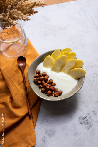 Breakfast bowl of yogurt with apple and hazelnuts	
