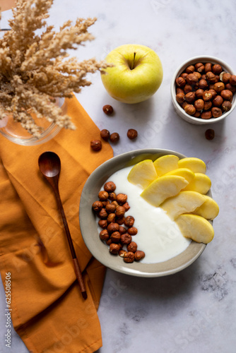 Breakfast bowl of yogurt with apple and hazelnuts	
