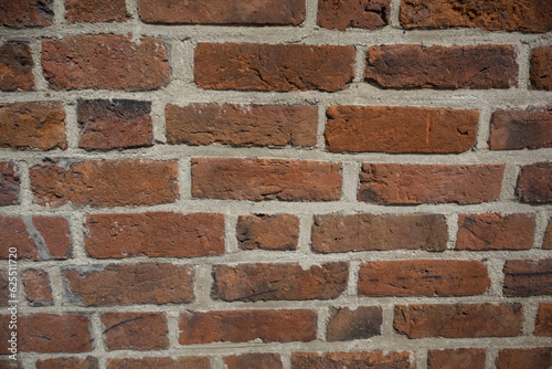 Textured red color brick wall background closeup 