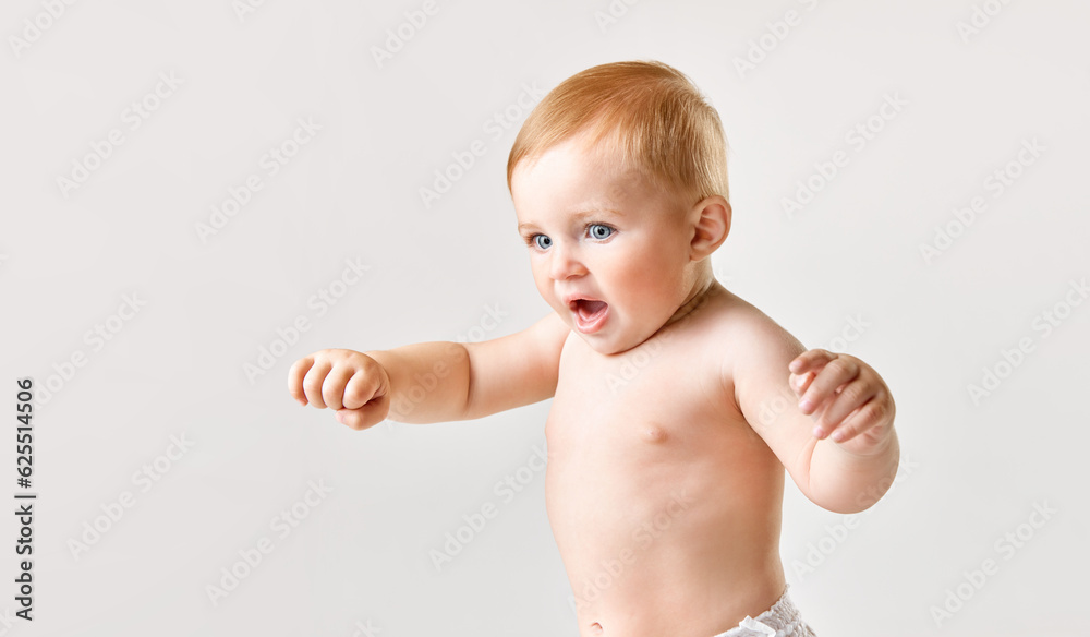 Portrait of beautiful little baby, toddler making first steps, walking, standing against white studio background. Concept of childhood, newborn lifestyle, happiness, care. Copy space for ad Portrait of beautiful little baby, toddler making first steps, walking, standing against white studio background. Concept of childhood, newborn lifestyle, happiness, care. Copy space for ad