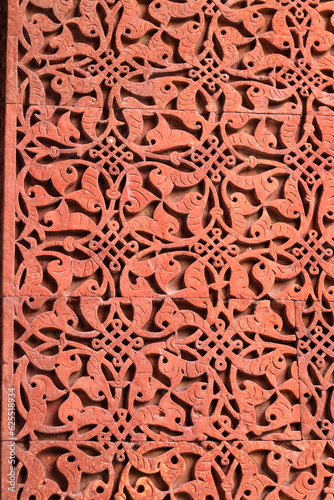 Wall seamless pattern - traditional Islamic background. Decorative element of stone carved wall. Islamic symbols, Qutub (Qutb) Minar red sandstone and marble in 1199 AD. Unesco World Heritage. India.