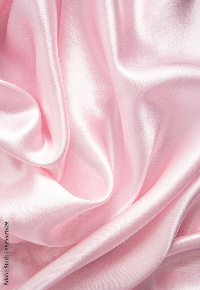The delicate texture of the waves of pink silk satin fabric. Vertical ...