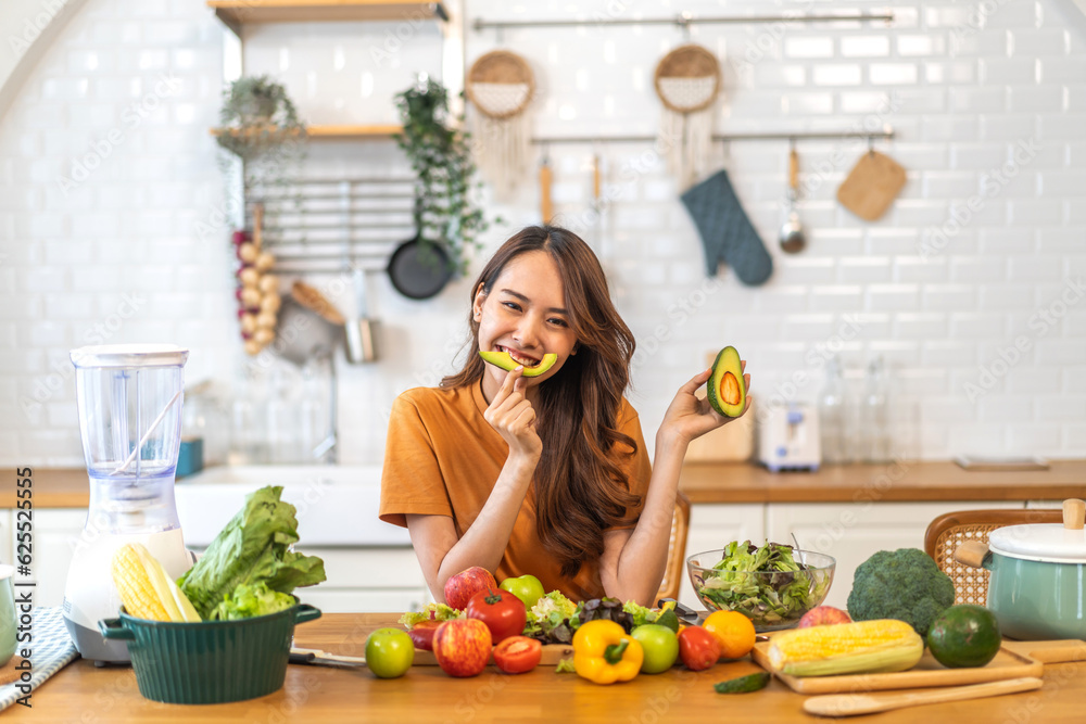 Portrait of beauty body slim healthy asian woman having fun hold avocado cooking preparing vegan food healthy eat with fresh vegetable salad, vegetarian in kitchen at home.Diet.Fitness, healthy food - obrazy, fototapety, plakaty 